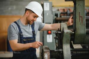 trabajador en protector ropa en fábrica utilizando máquina foto