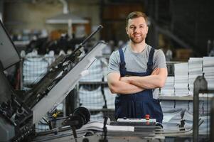 Man working in printing house with paper and paints photo