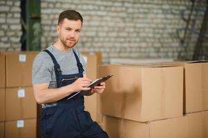 Warehouse worker carrying a carton for delivery to production stock. photo