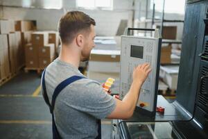 Man working in printing house with paper and paints photo