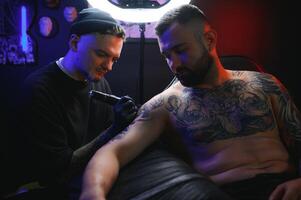 Professional tattoo artist makes a tattoo photo