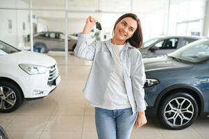 contento mujer cliente hembra comprador cliente escoger auto querer a comprar nuevo automóvil en coche sala de exposición foto