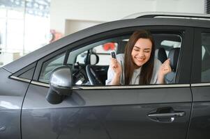 contento propietario sentado dentro su coche participación llaves foto