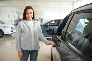 Beautiful young female client customer choosing new car photo