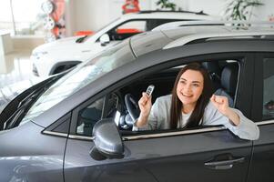 contento mujer con coche llave sentado en moderno auto. bandera diseño foto