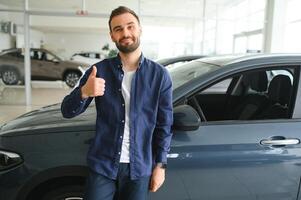 Young man is choosing a new vehicle in car dealership photo