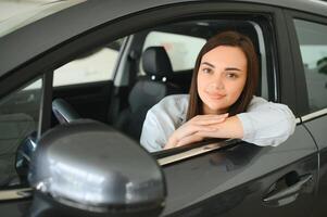 Beautiful young female client customer choosing new car photo
