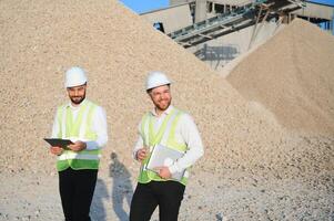 Two engineers at an industrial plant. Crushed stone production plant. Gravel photo