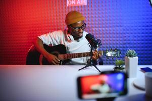 africano americano hombre con guitarra en grabación estudio foto