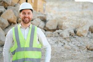 Worker in hardhat standing in stone quarry photo