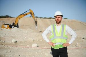 Male worker with bulldozer in sand quarry photo