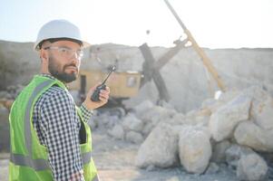 Male worker with bulldozer in sand quarry photo