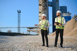 Two engineers or businessmen at an industrial plant. Plant for extraction and production of gravel photo