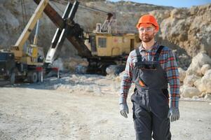 Extraction of stone. Male worker next to stone quarry. Engineer at construction site photo