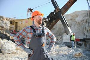 Extraction of stone. Male worker next to stone quarry. Engineer at construction site photo