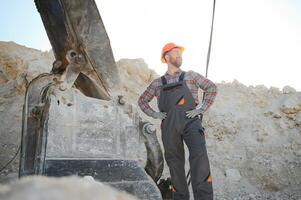 Male worker with bulldozer in sand quarry photo