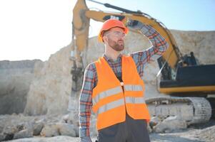 Male worker with bulldozer in sand quarry photo