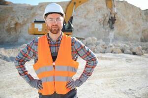 Extraction of stone. Male worker next to stone quarry. Engineer at construction site photo