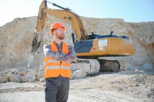 Male worker with bulldozer in sand quarry photo