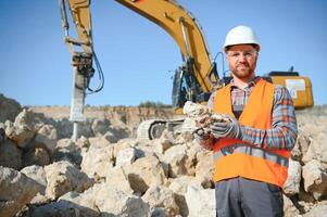 Portrait of a worker standing on the background of a stone quarry photo