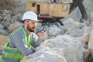 extracción de Roca. masculino trabajador siguiente a Roca cantera. ingeniero a construcción sitio foto