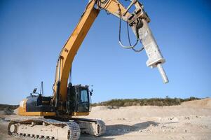 Excavator with hydraulic hammer on road construction works photo