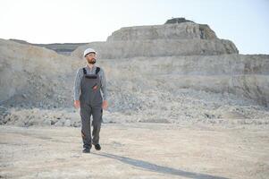 Portrait of a worker standing on the background of a stone quarry photo