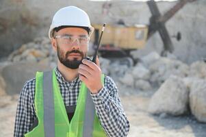 Extraction of stone. Male worker next to stone quarry. Engineer at construction site photo