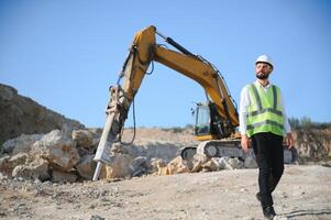 Worker in hardhat standing in stone quarry photo