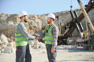 Workers talking in rock quarry photo