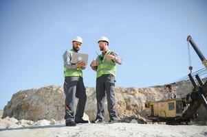 Two workers and quarry in background photo