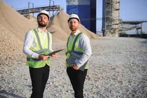 Two engineers or businessmen at an industrial plant. Plant for extraction and production of gravel photo