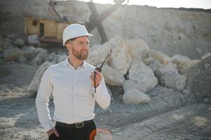 Extraction of stone. Male worker next to stone quarry. Engineer at construction site photo