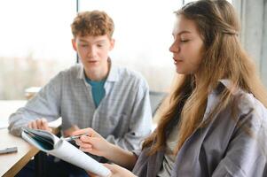 students sitting in a classroom, studying, discussing photo