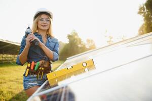 women engineer working on checking and maintenance equipment at green energy solar power plant photo