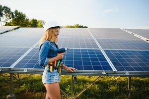 mujer ingeniero trabajando en comprobación equipo a verde energía solar poder planta comprobación solar panel y estructura con tableta Lista de Verificación foto