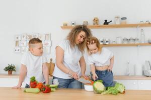 Family in a kitchen. Beautiful mother with children. Lady in white blouse. photo