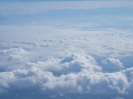 Aerial view of clouds and sky seen through the airplane window photo