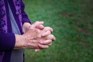 Close-up of hands senior woman joined together for prayer. Concept of aged people and religion photo