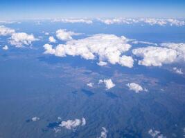 Aerial view of lands and clouds seen through the airplane window photo