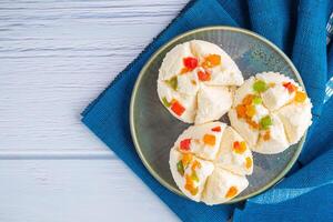 Top view of Thai steamed cupcakes topped with dry fruit on a plate on a blue cloth with a wooden background.. photo