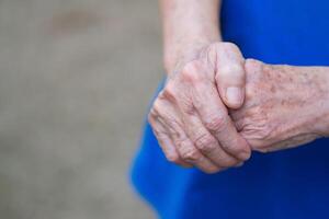 Close-up of elderly woman's hands joined together. Focus on hands wrinkled skin. Space for text. Health care concept photo