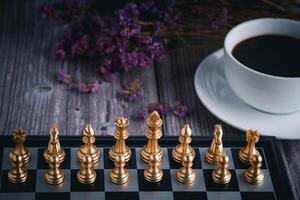 Front view of a chess game on a chessboard with a white coffee cup blur background. Business game competitive strategy. Concept of strategy for business photo