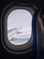 Aerial view of lands and clouds seen through airplane window photo