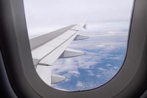 Aerial view of lands and clouds seen through airplane window photo