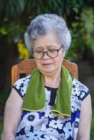 retrato de mayor mujer sentado y ojos cerrado en el jardín. foto