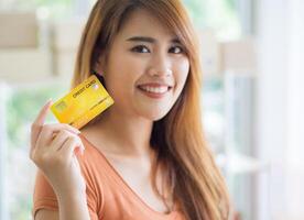 Close-up of hand woman holding a credit card prepare for shopping online while standing in the office. Space for text. Concept of business and e-commerce photo