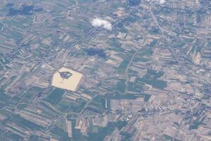 Aerial view of agricultural field, river and clouds seen through airplane window photo