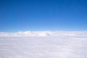 Aerial view of sky and clouds are seen through the airplane window photo
