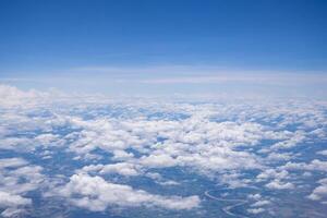 Aerial view of lands and clouds seen through airplane window photo